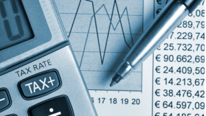 Calculator displaying tax rate next to financial data and graphs, illustrating key updates in Indonesia 2025 tax policies.