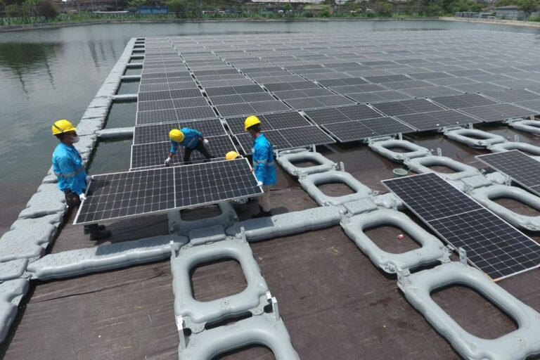 Workers install solar panels at Indonesia’s largest floating solar power plant in Semarang, supporting the Indonesia clean energy transition.