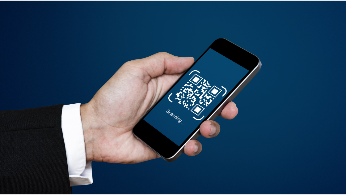 A person holding a smartphone scanning a QR code, illustrating the risks of QR code scam in digital transactions.