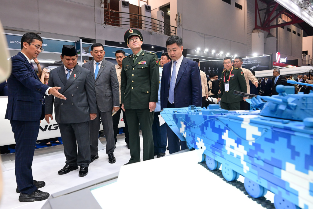 President Prabowo Subianto with Chinese military officials inspecting a model armored vehicle at the Indonesia Defense Expo 2025 in Jakarta.