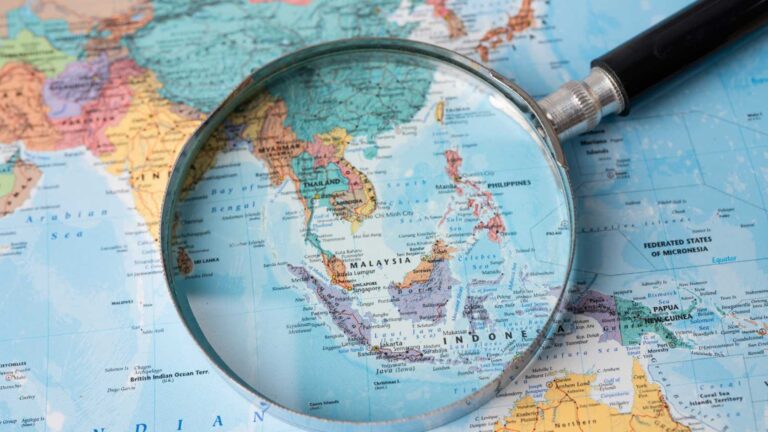 Map of Southeast Asia under a magnifying glass, illustrating Southeast Asia investment growth across key countries in the region.