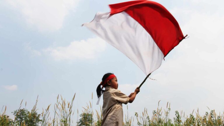A little girl waving the Indonesian flag during Indonesia's independence day