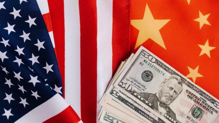Chinese investment in Indonesia surges as US tariffs push companies to relocate, symbolized by US and China flags with US dollar bills.