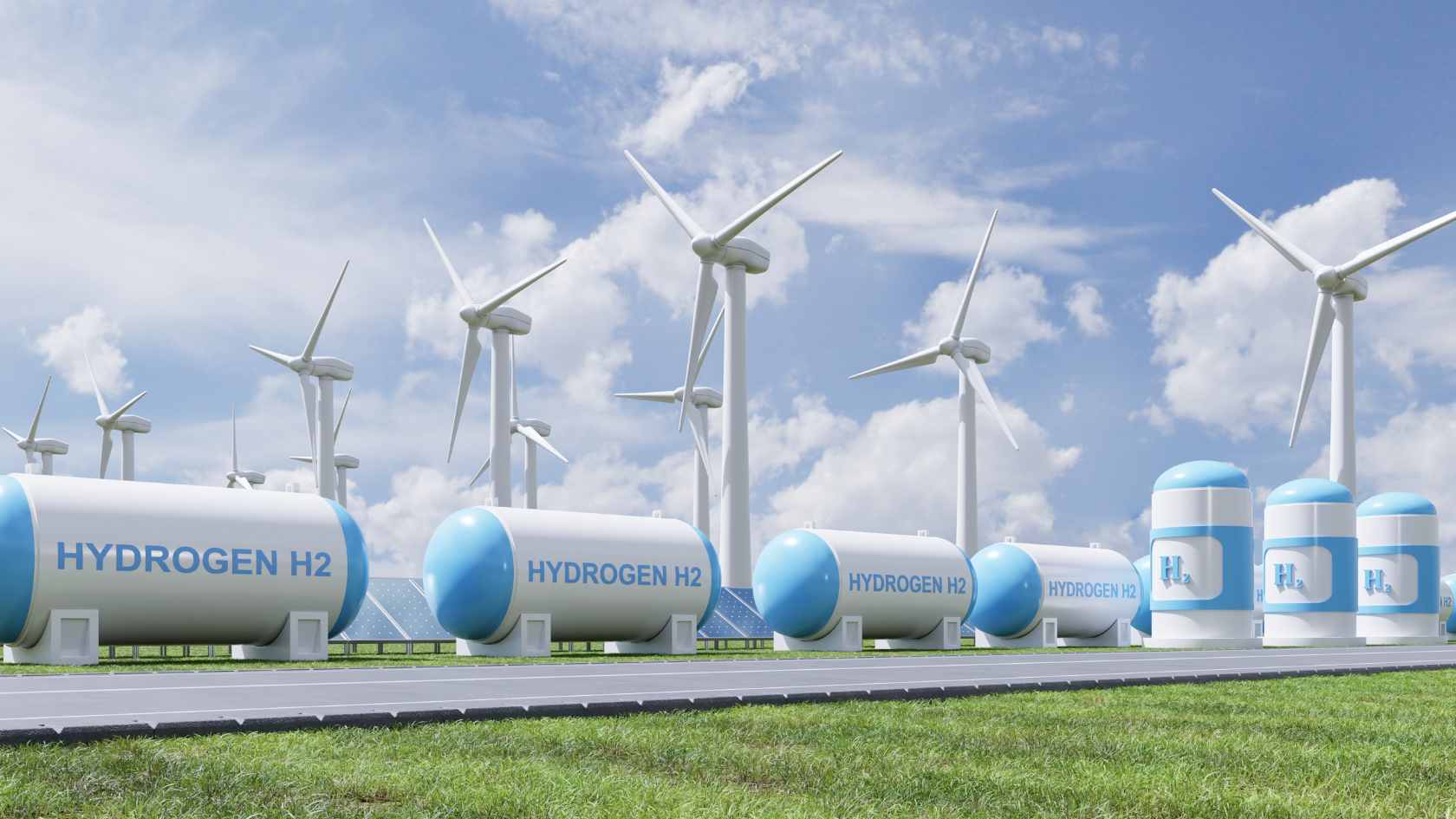 Hydrogen storage tanks labeled H2 with wind turbines in the background, representing green hydrogen and the Pertamina NRE HyET partnership for clean energy transition.