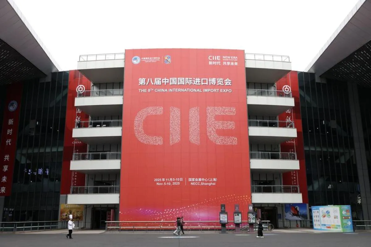 A large red entrance banner for the 8th China International Import Expo at the NECC Shanghai, highlighting the CIIE 2025 trade as visitors walk across the plaza.