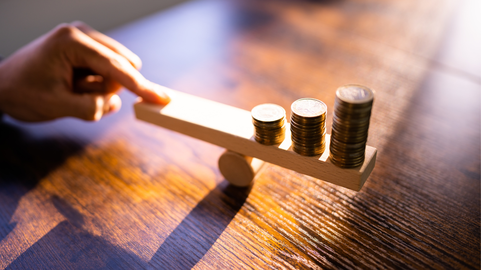 A hand balances stacked coins on a wooden scale, symbolizing Indonesia economy in 2026 remaining stable amid growth and fiscal pressures.